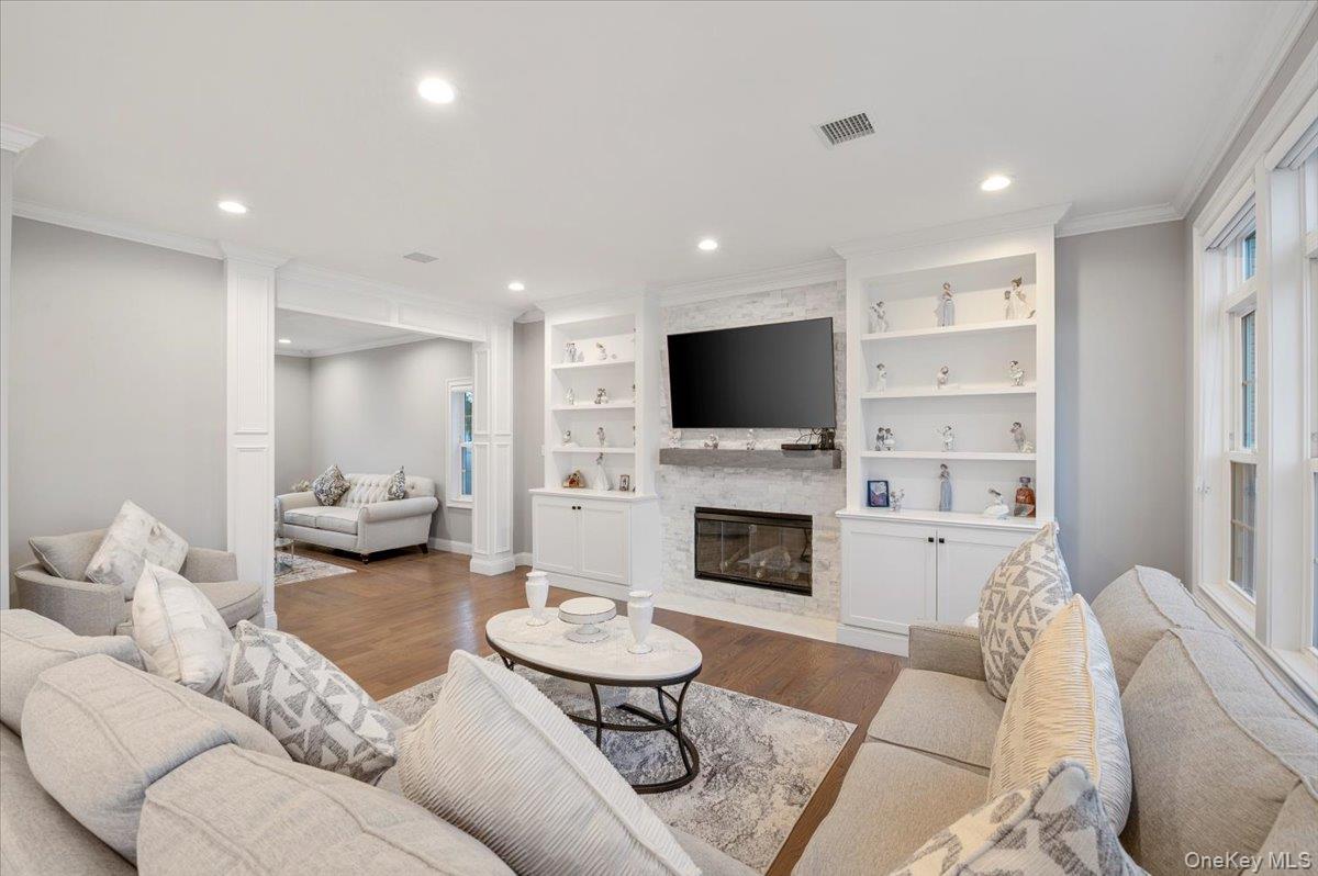 1427 Bellmore Road North Bellmore, NY 11710 - Photo 19 of 38 a living room with furniture a fireplace and a flat screen tv