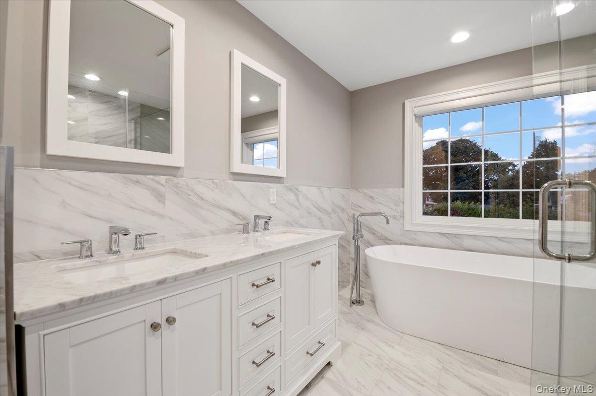 1427 Bellmore Road North Bellmore, NY 11710 - Photo 25 of 38 a bathroom with a double vanity sink mirror and bathtub