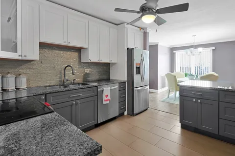 a kitchen with stainless steel appliances granite countertop a sink stove and refrigerator