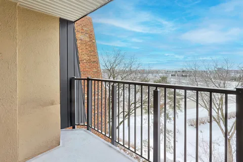 a view of a balcony with wooden floor and fence