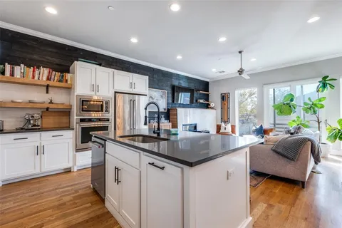 a kitchen with stainless steel appliances granite countertop a sink refrigerator and cabinets