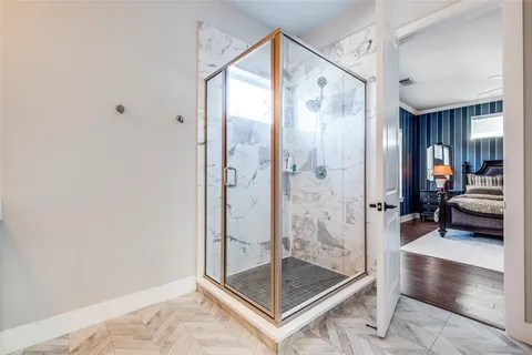 a bathroom with a glass shower door and a glass door