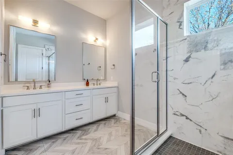 a spacious bathroom with double vanity and a mirror