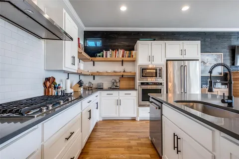 a kitchen with stainless steel appliances a sink stove and cabinets