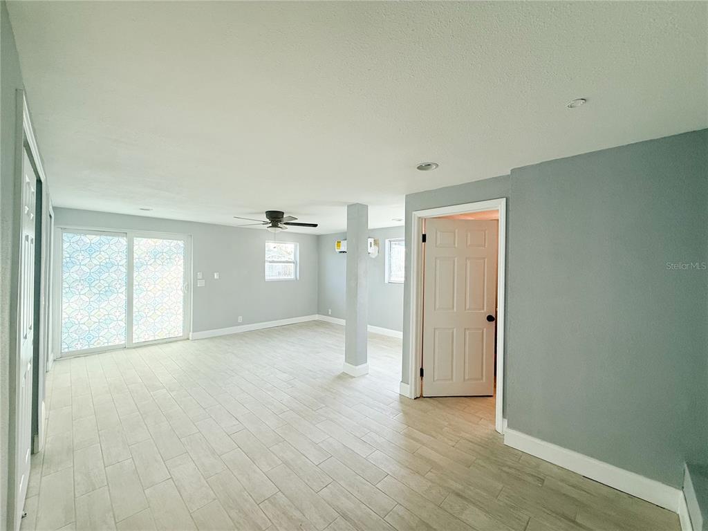 14000 Miramar Avenue, Unit A Madeira Beach, FL 33708 - Photo 8 of 20 a view of empty room with wooden floor and window