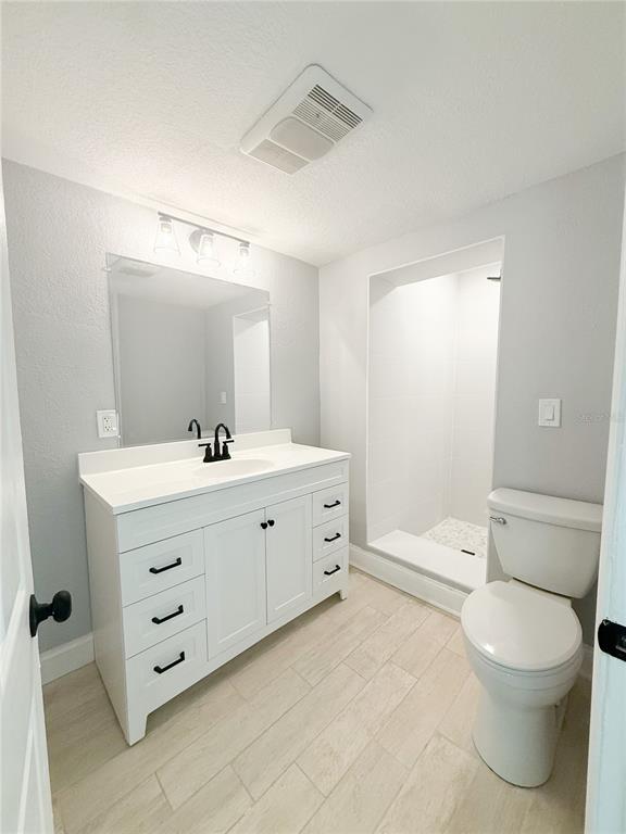 14000 Miramar Avenue, Unit A Madeira Beach, FL 33708 - Photo 10 of 20 a bathroom with a double vanity sink toilet mirror and bathtub