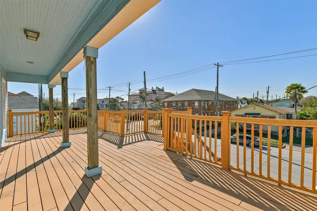 a view of a balcony with wooden floor and iron stairs
