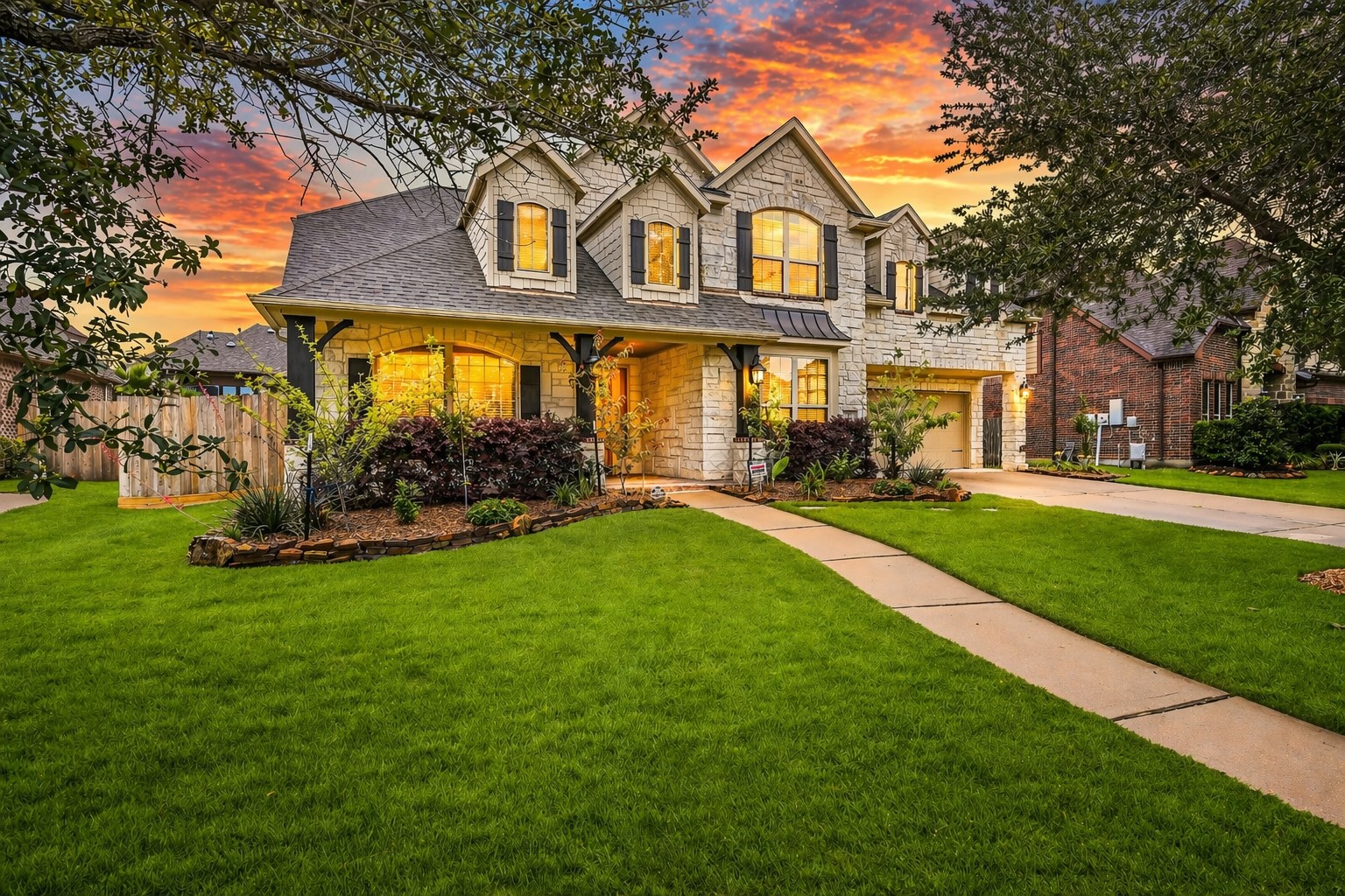 1008 Point Isabel Lane Friendswood, TX 77546 - Photo 1 of 50 Arrive to a striking stone elevation framed by mature trees and manicured landscaping, where a welcoming front porch and warm evening glow set the tone for this beautifully maintained 5-bedroom, 4 bath West Ranch stunner.