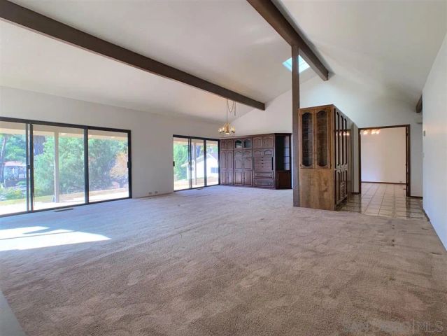 a view of an empty room with a fireplace and a window