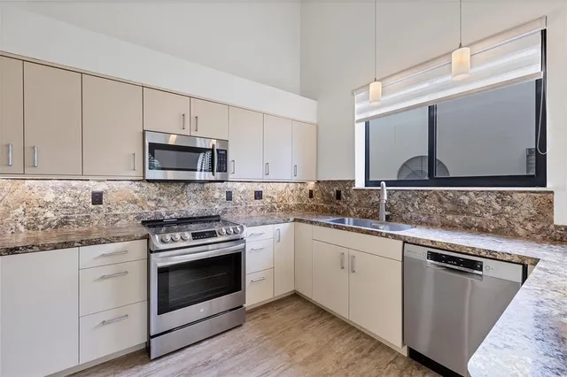 an empty room with windows and ceiling fan