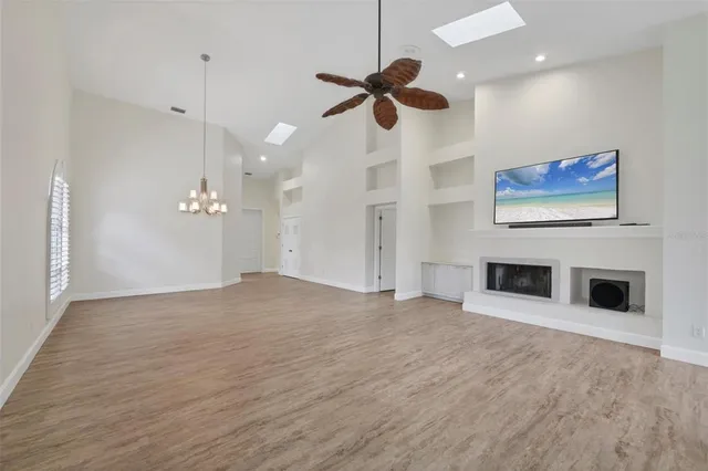 a view of a room with wooden floor fireplace and windows