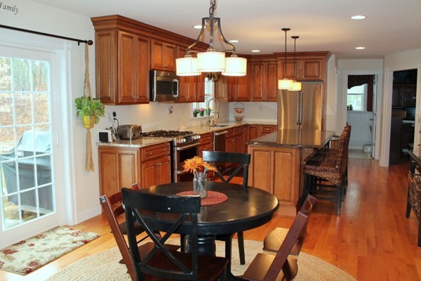 280 River St Extension Billerica, MA 01821 - Photo 6 of 23 a kitchen with stainless steel appliances granite countertop a stove a sink dishwasher a dining table and chairs with wooden floor