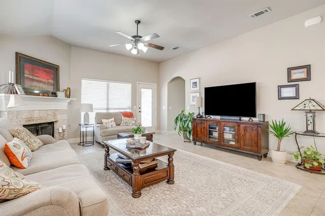 a living room with furniture a flat screen tv and a fireplace