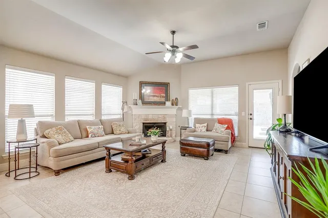 a living room with furniture a flat screen tv and a fireplace