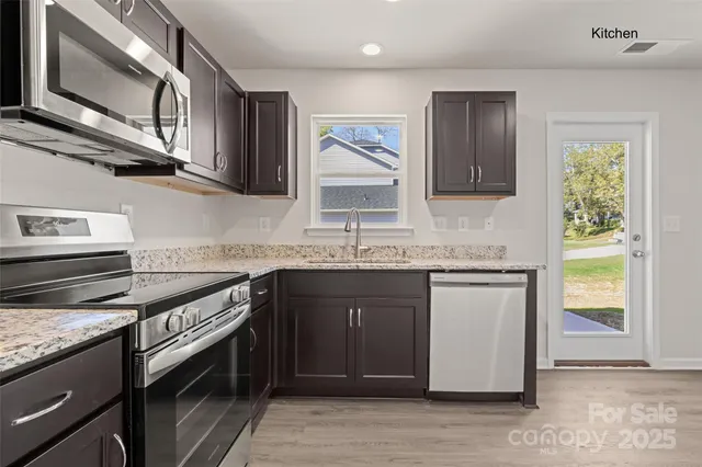 a kitchen with stainless steel appliances granite countertop a sink and a stove