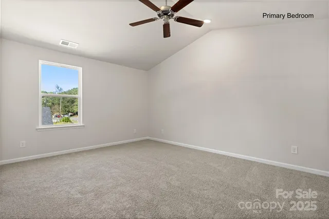 an empty room with windows and ceiling fan