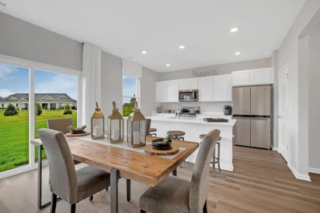 a kitchen with a dining table chairs refrigerator and cabinets