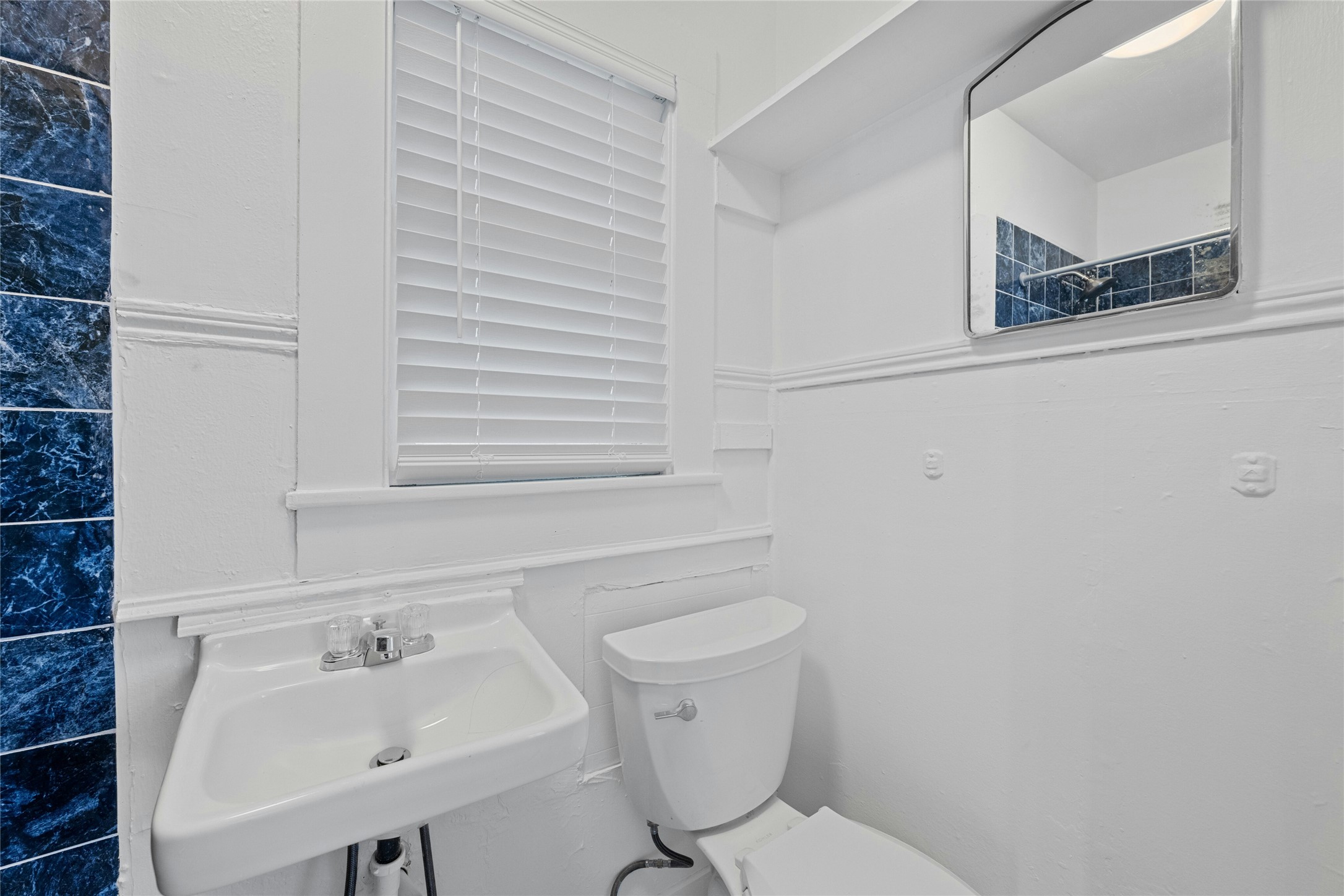 2201 Leon Street, Unit G Austin, TX 78705 - Photo 10 of 17 Bathroom featuring a wall-mounted sink, toilet, and mirrored vanity