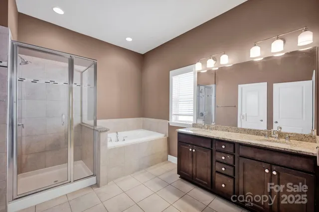 a spacious bathroom with a double vanity sink a large mirror and a bathtub