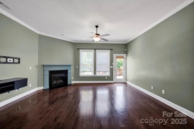 an empty room with fireplace wooden floor and windows
