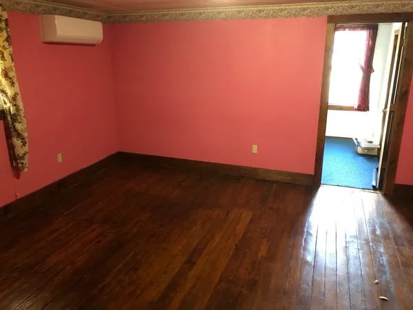 a view of an empty room and wooden floor