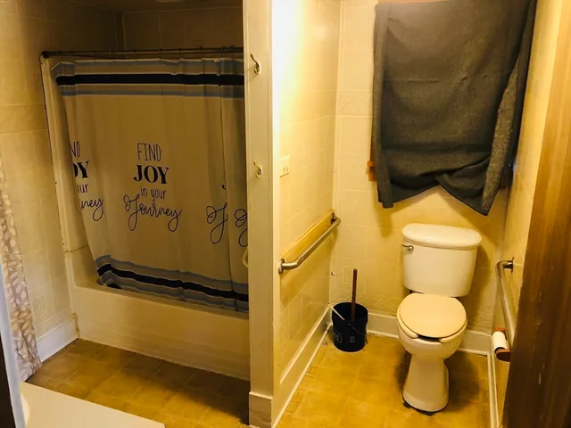 a bathroom with a toilet and a shower