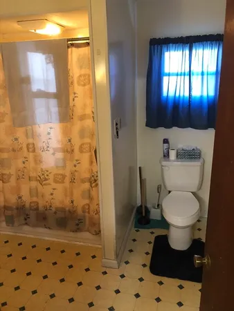 a bathroom with a toilet and a shower