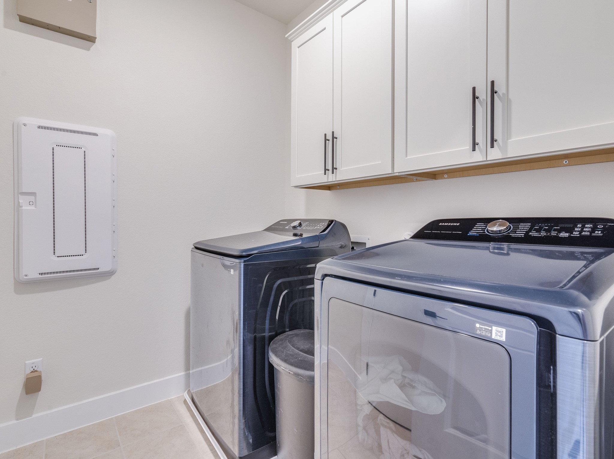 297 Tree Nut Loop Buda, TX 78610 - Photo 20 of 25 Laundry room has additional storage cabinets and tankless water heater. The smart home hub is the white box on the wall.