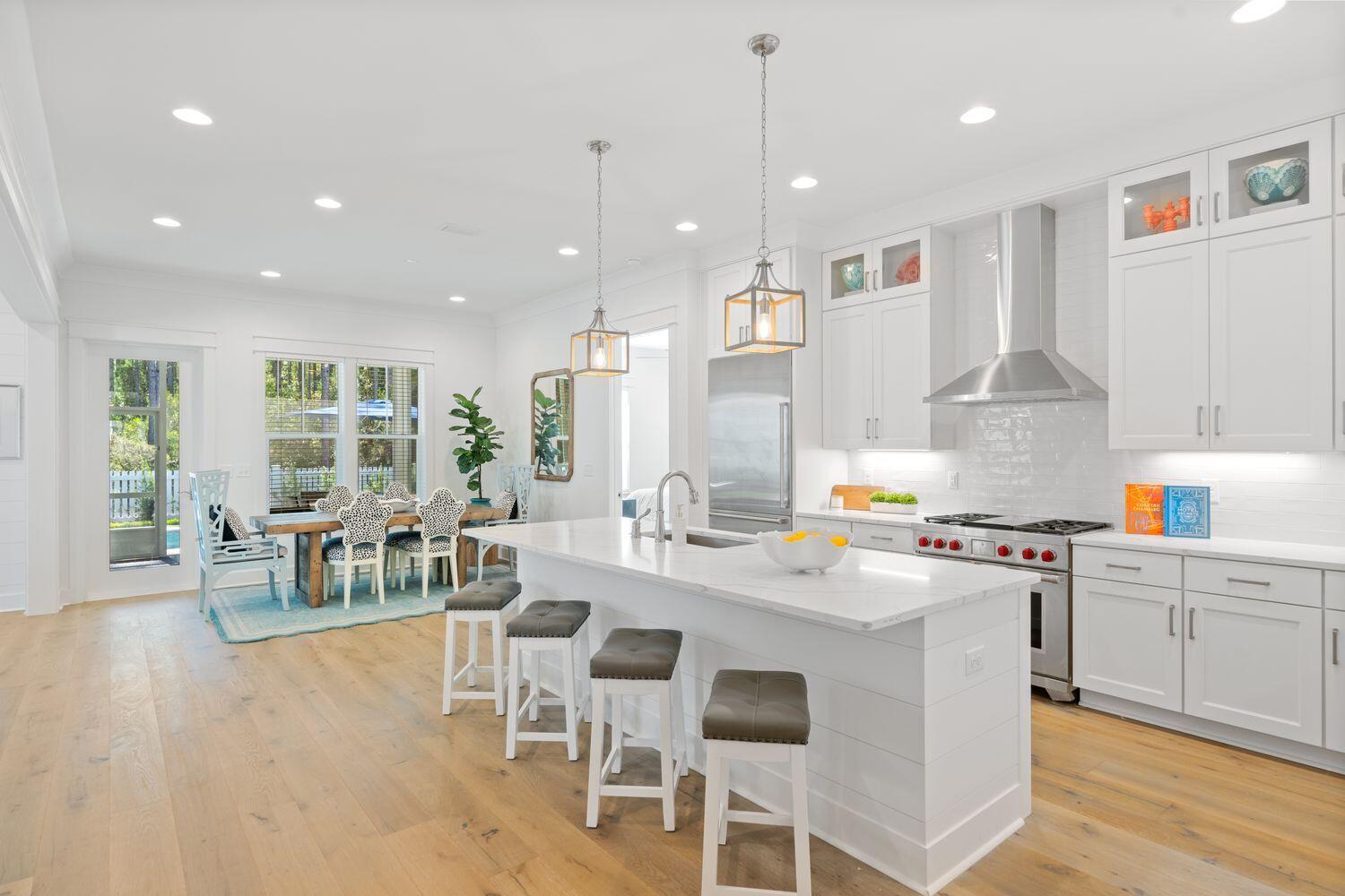 117 Rosecourt St Inlet Beach Inlet Beach, FL 32461 - Photo 23 of 62 a kitchen with stainless steel appliances kitchen island granite countertop a stove a sink a dining table and chairs with wooden floor