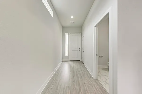 a view of a hallway with wooden floor