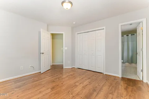 an empty room with wooden floor and sliding door