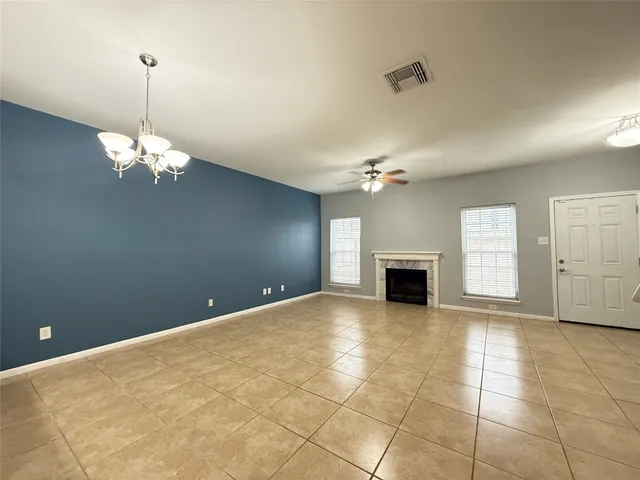 a view of a livingroom with a chandelier fan and windows