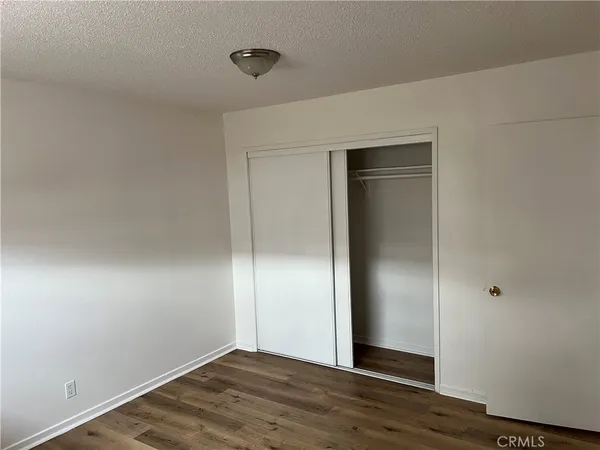 an empty room with wooden floor and closet