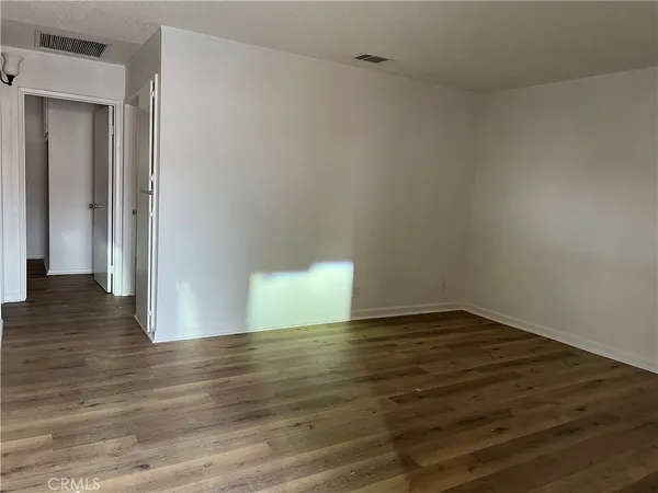 a view of an empty room and wooden floor