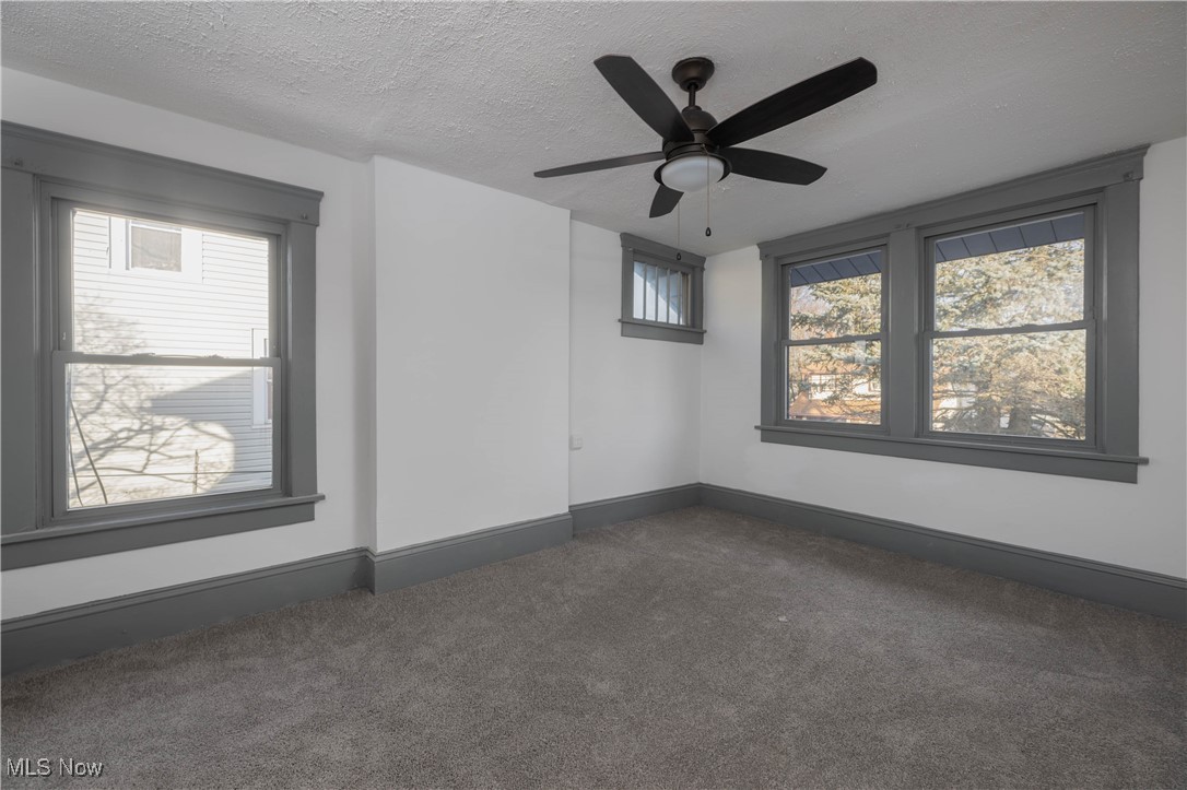 2700 9th Street Northwest Canton, OH 44708 - Photo 20 of 33 Empty room featuring dark colored carpet, a textured ceiling, and ceiling fan