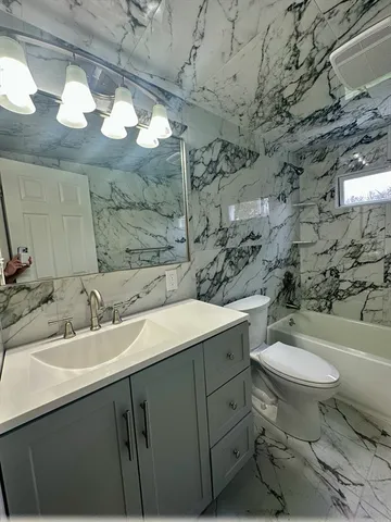 a bathroom with a sink toilet and a mirror