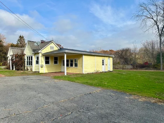 a view of a big house with a big yard and large trees
