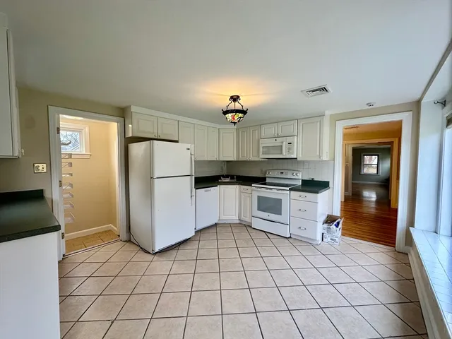 a kitchen with a refrigerator a stove a microwave and cabinets
