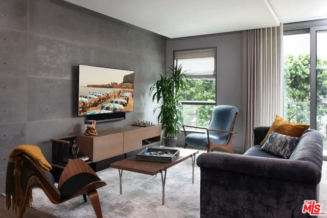 a living room with furniture a window and a flat screen tv