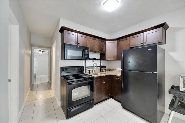 a kitchen with a refrigerator sink and stove top oven