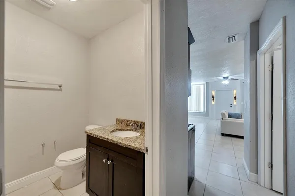 a bathroom with a granite countertop sink a toilet and a mirror