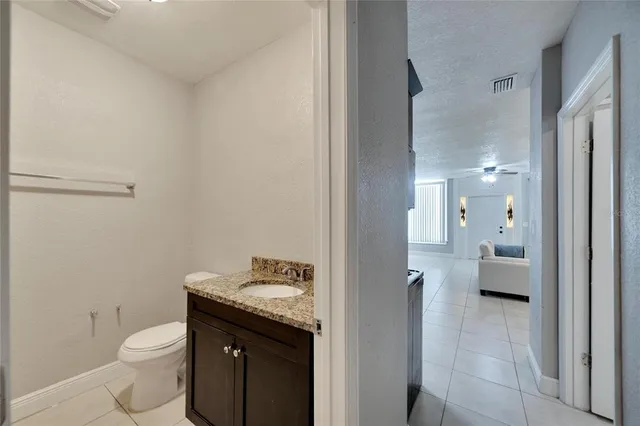 a bathroom with a granite countertop sink a toilet and a shower