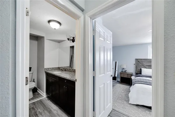 a bathroom with a granite countertop sink a toilet and a mirror