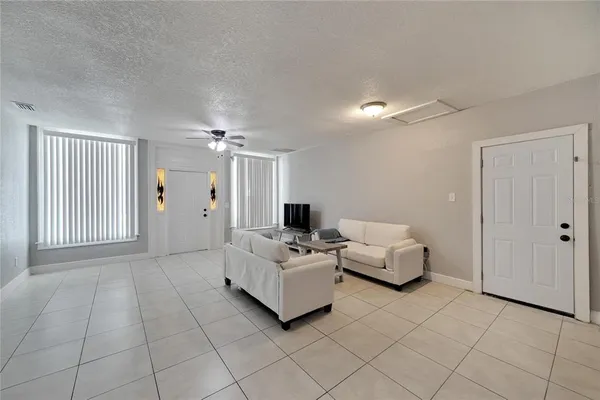 a living room with furniture and a ceiling fan
