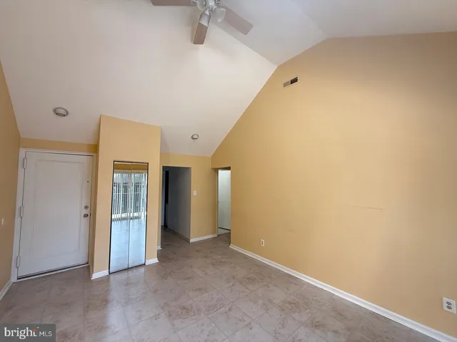 an empty room with windows and fireplace