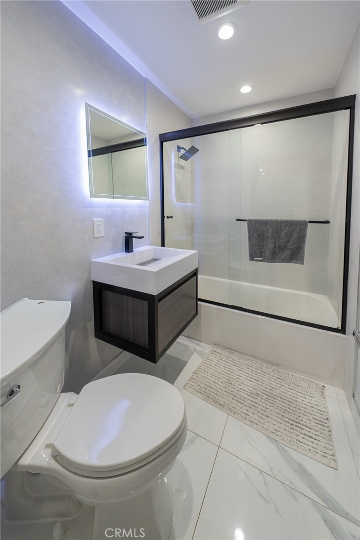 7719 Rhodes Avenue North Hollywood, CA 91605 - Photo 13 of 16 a bathroom with a sink a toilet and mirror