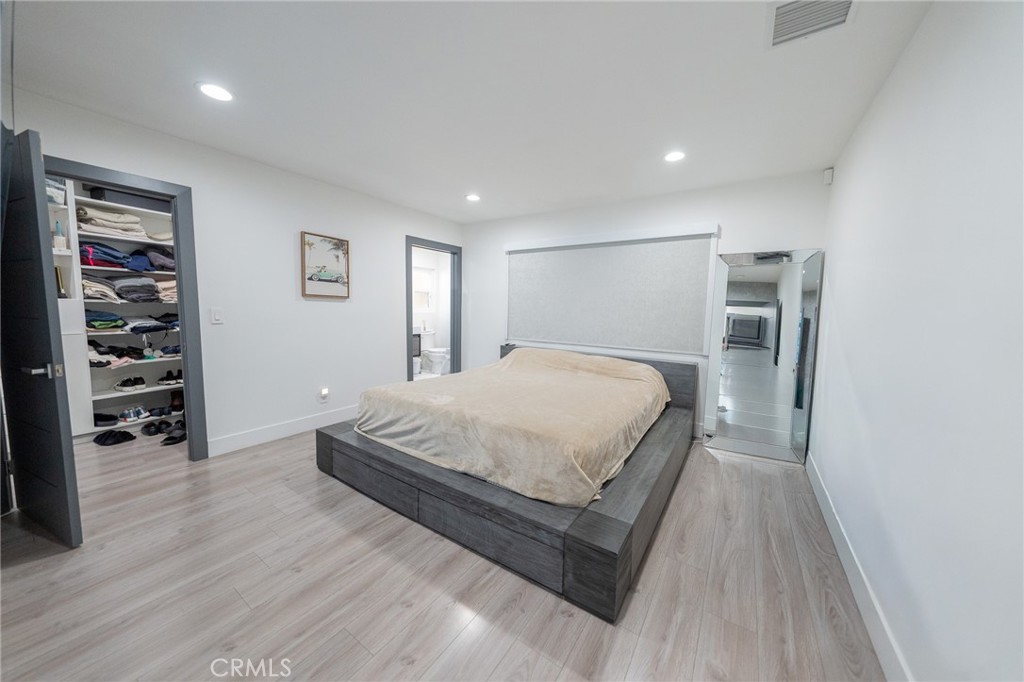 7719 Rhodes Avenue North Hollywood, CA 91605 - Photo 14 of 16 a spacious bedroom with a bed and a walk in closet