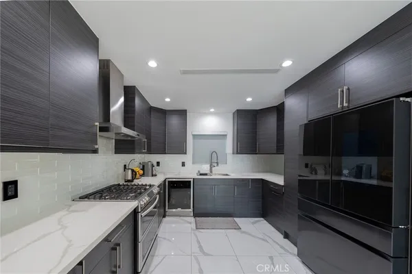 a kitchen with stainless steel appliances granite countertop a sink stove and refrigerator