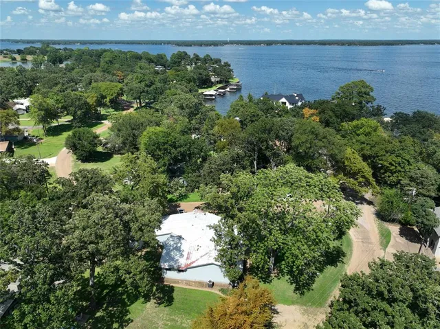 an aerial view of a house with a garden and lake view