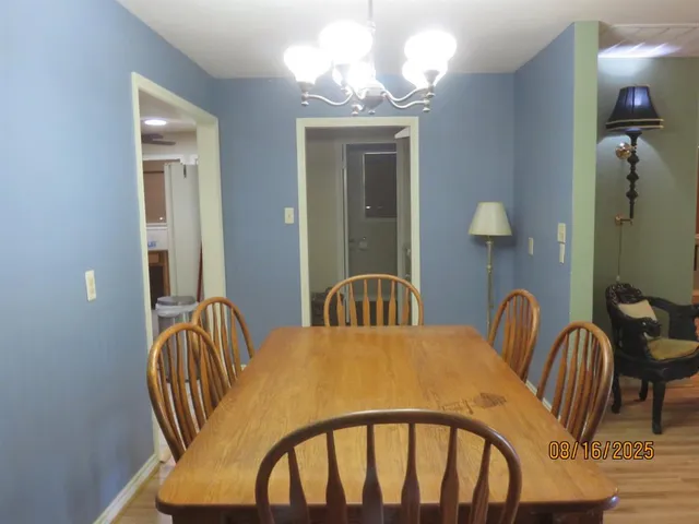 a view of a dining room with furniture and chandelier